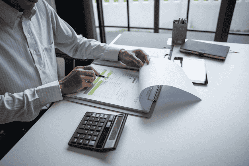 Person prüft Finanzbericht mit Diagrammen als Teil des finanziellen Jahreschecks